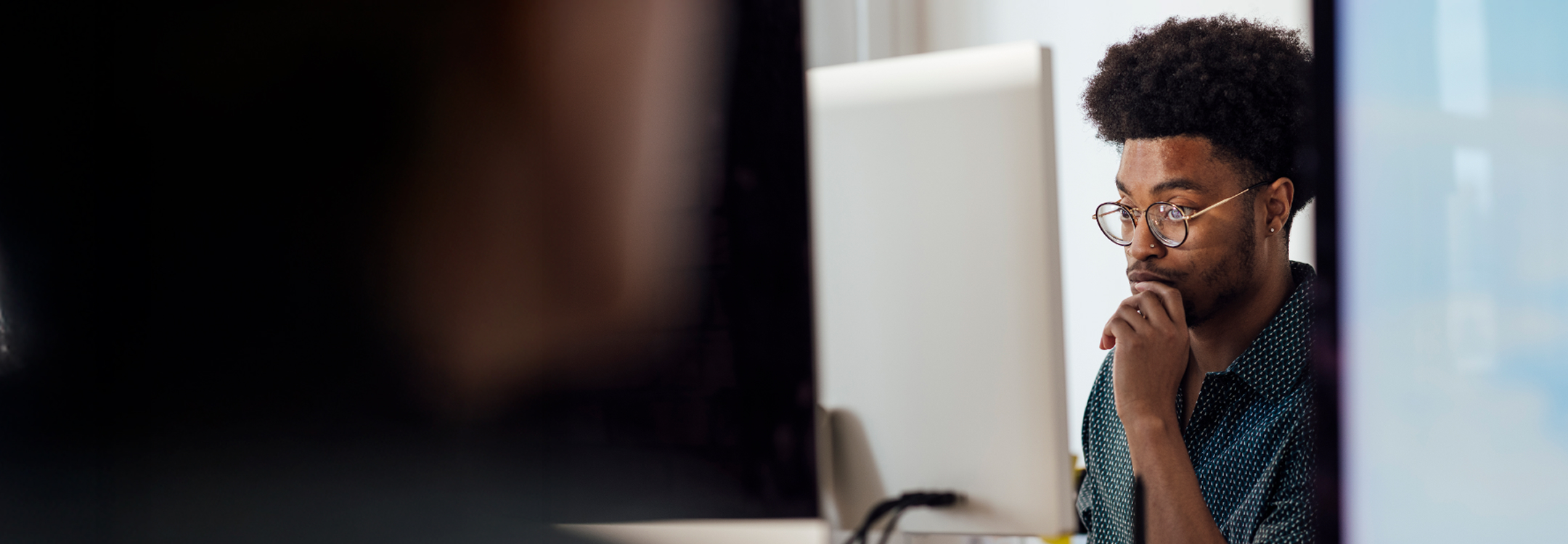Person looking thoughtfully at a computer screen