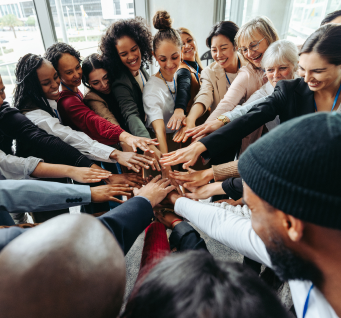 Group of people placing hands together in unity